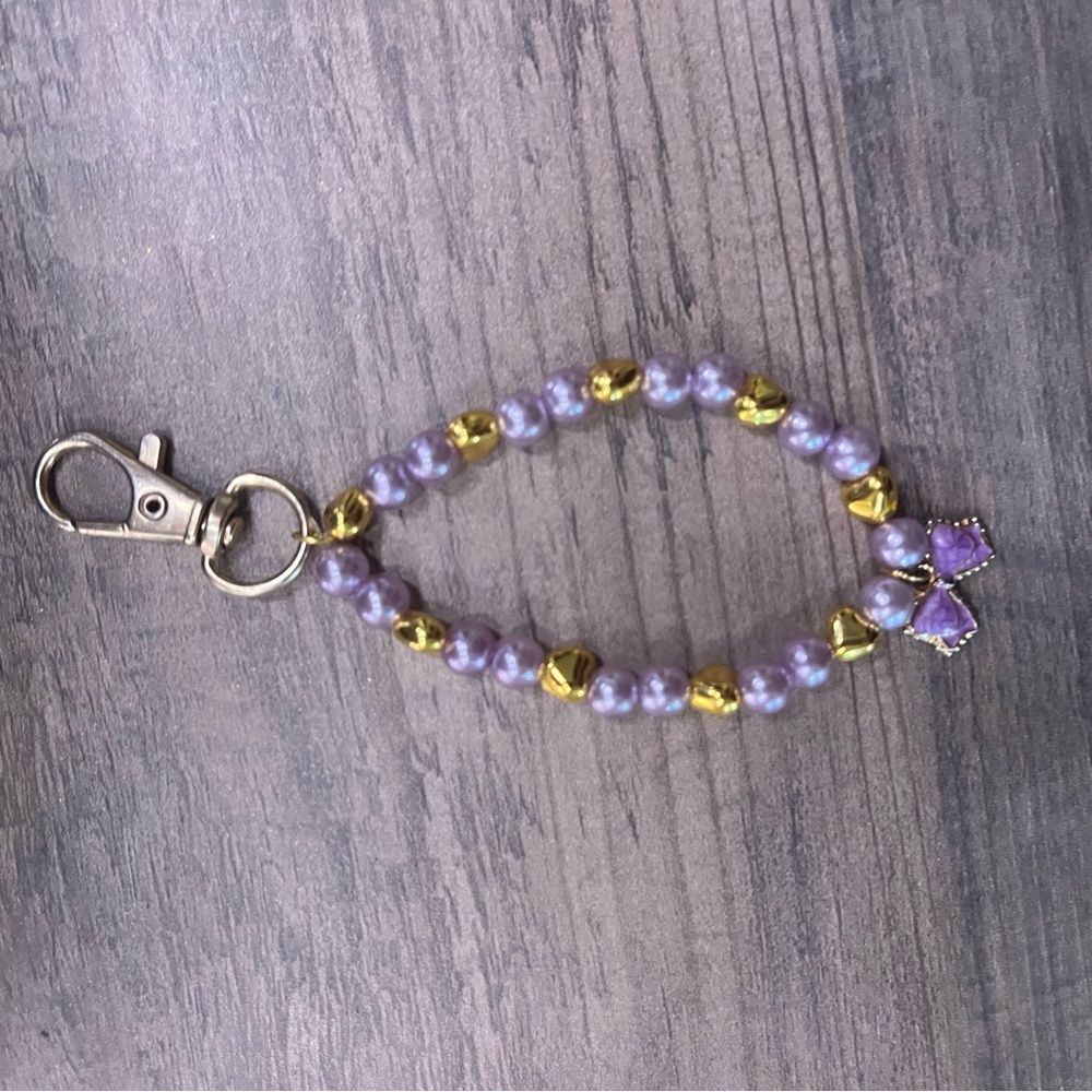 Handmade gold bow keychain with purple and gold hearts!